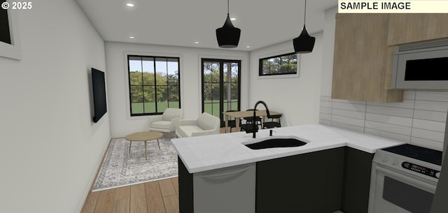 kitchen featuring kitchen peninsula, backsplash, white appliances, a healthy amount of sunlight, and sink