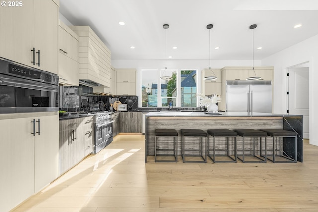 kitchen with pendant lighting, a kitchen bar, a center island, and premium appliances