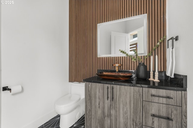 bathroom with tile patterned flooring, vanity, and toilet