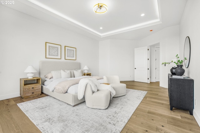 bedroom with a raised ceiling and hardwood / wood-style flooring