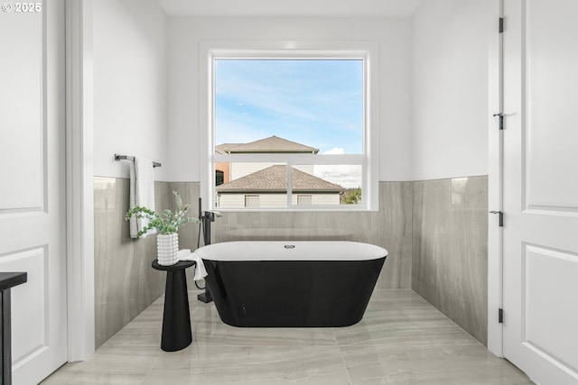 bathroom with tile walls and a tub to relax in