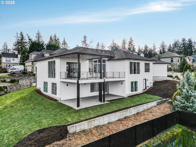 back of property with a lawn and a patio area