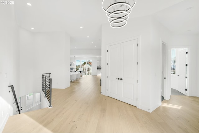 hall featuring a notable chandelier and light hardwood / wood-style flooring