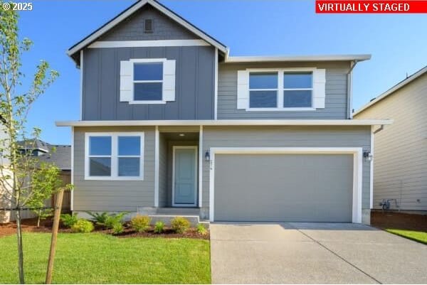 10587 SE Webelos Way, Happy Valley, OR 97086 - view of front of property with board and batten siding, concrete driveway, a garage, and a front yard