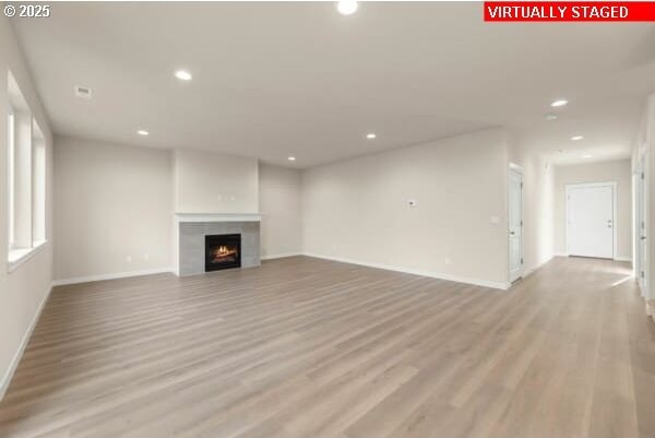 10587 SE Webelos Way, Happy Valley, OR 97086 - unfurnished living room featuring recessed lighting, light wood-type flooring, and a fireplace
