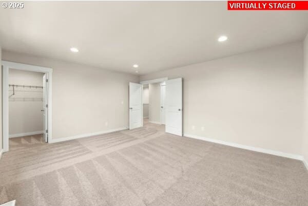 10587 SE Webelos Way, Happy Valley, OR 97086 - unfurnished bedroom featuring recessed lighting, light carpet, and a walk in closet