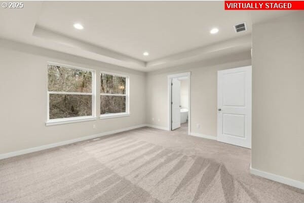 10587 SE Webelos Way, Happy Valley, OR 97086 - unfurnished bedroom with carpet, a tray ceiling, and recessed lighting