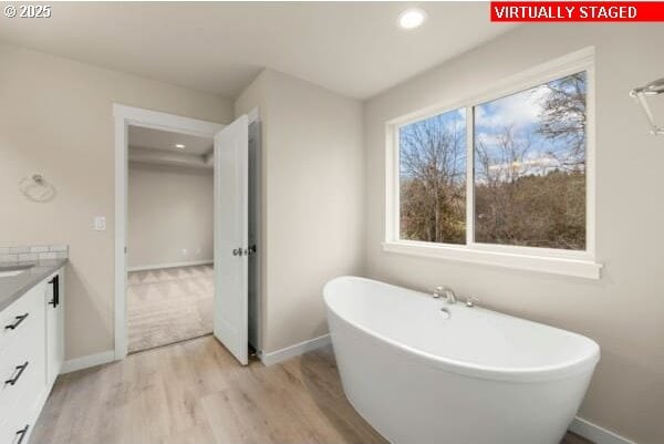 10587 SE Webelos Way, Happy Valley, OR 97086 - full bathroom featuring a soaking tub, wood finished floors, vanity, and recessed lighting