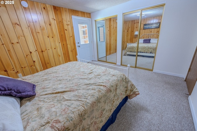 43605 State Highway 38 Unit 41, Reedsport, OR 97467 - bedroom with multiple closets, carpet, wooden walls, and a textured ceiling