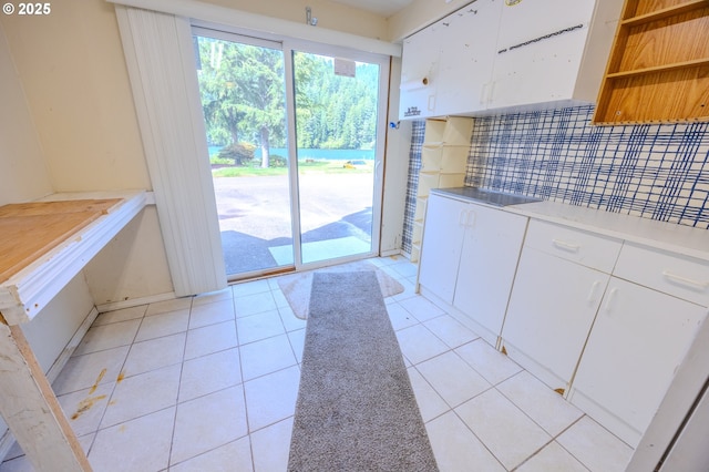 43605 State Highway 38 Unit 41, Reedsport, OR 97467 - kitchen featuring backsplash, light countertops, white cabinetry, and light tile patterned floors