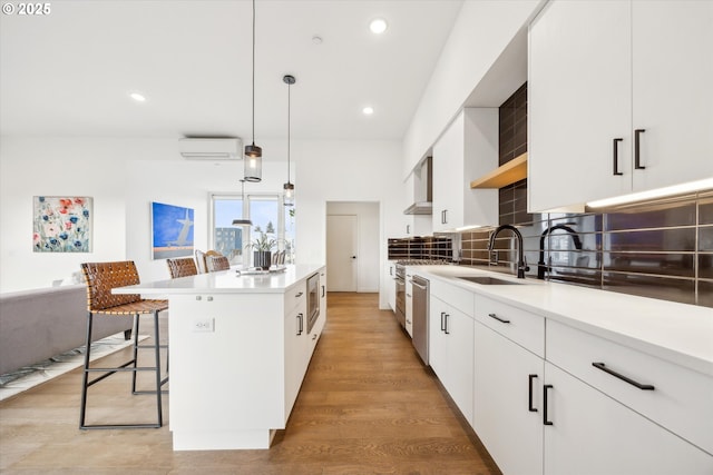 kitchen featuring sink, a center island, hanging light fixtures, and white cabinetry