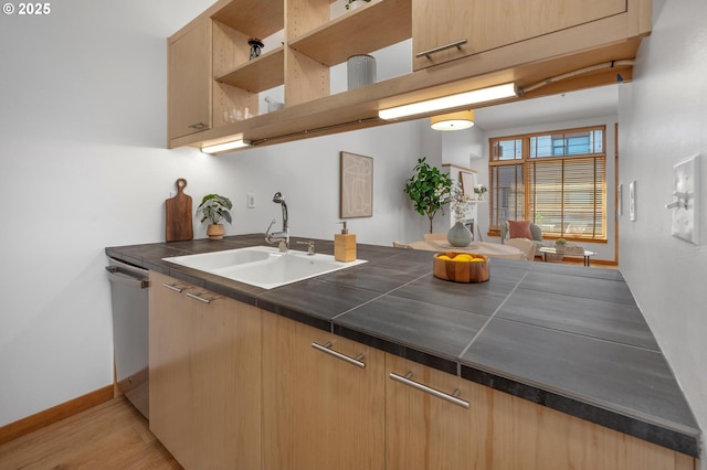 725 NW 10th Ave Unit 503, Portland, OR 97209 - kitchen featuring dishwasher, light wood-style flooring, open shelves, a peninsula, and tile countertops