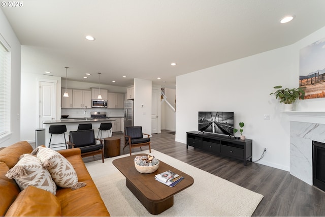 24200 SW Chestnut Ter, Sherwood, OR 97140 - living room featuring wood finished floors, recessed lighting, a high end fireplace, and stairs