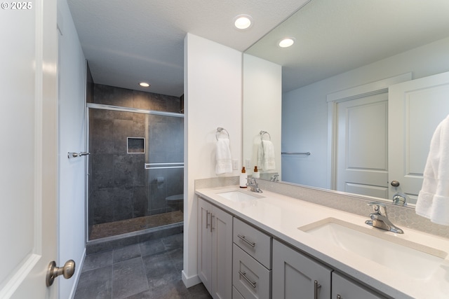 24200 SW Chestnut Ter, Sherwood, OR 97140 - bathroom featuring double vanity, a shower stall, and recessed lighting