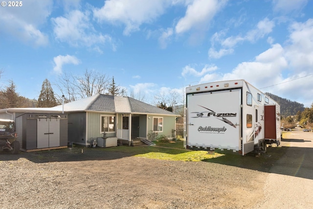 rear view of house with a storage shed and an outdoor structure