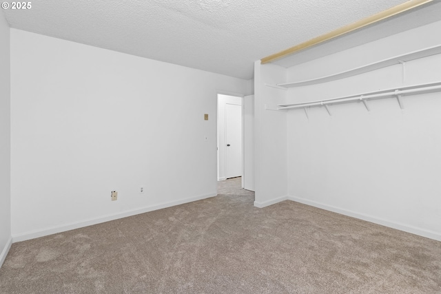 unfurnished bedroom with a closet, carpet flooring, a textured ceiling, and baseboards