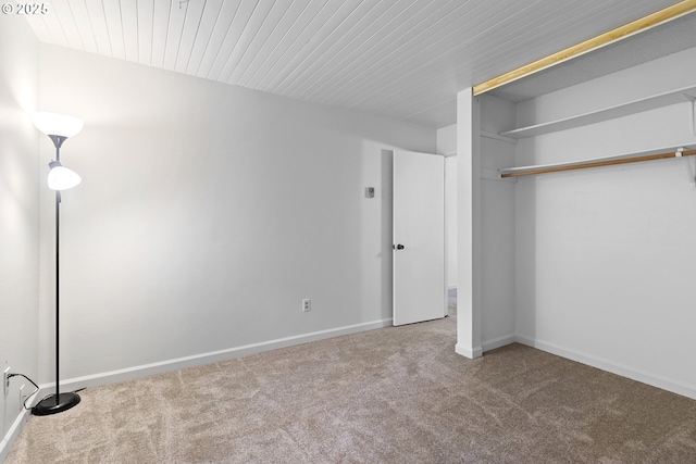 unfurnished bedroom with a closet, carpet flooring, and baseboards