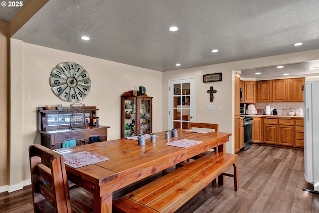 dining space with wood finished floors, recessed lighting, and baseboards