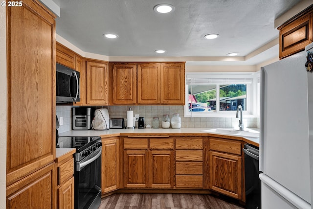 kitchen with freestanding refrigerator, stainless steel microwave, electric range, dishwashing machine, and dark wood-style flooring