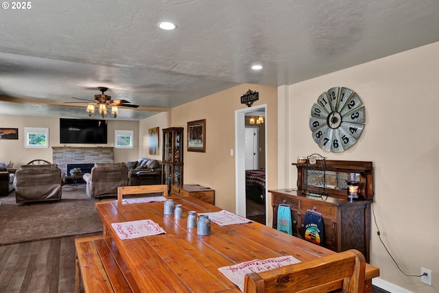 dining space featuring dark wood finished floors, ceiling fan, a fireplace, and recessed lighting