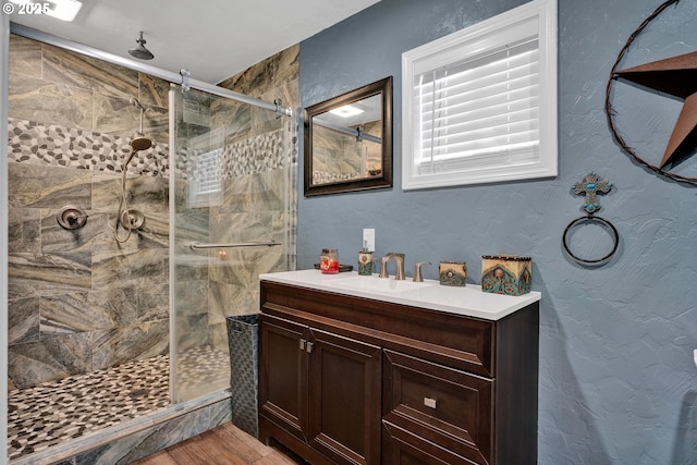 bathroom featuring a shower stall, vanity, and wood finished floors