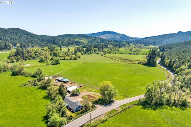 view of rural area featuring mountains and a forest