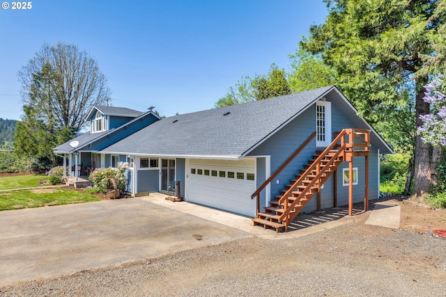 view of front of home with dirt driveway, an attached garage, a porch, stairs, and roof with shingles