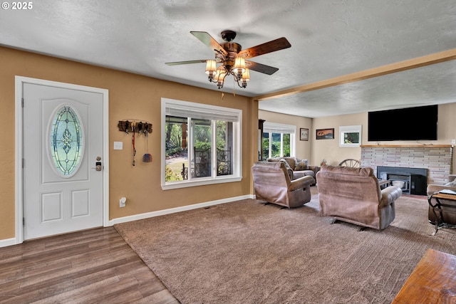 living room featuring ceiling fan, carpet, a fireplace, and baseboards