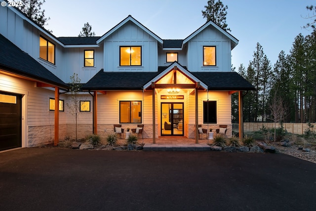 19550 Buck Canyon Rd, Bend, OR 97702 - view of front of property featuring a garage, stone siding, board and batten siding, a porch, and driveway