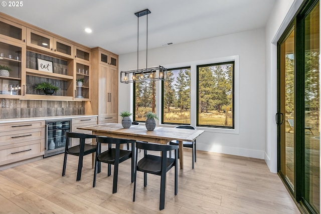 dining space featuring wine cooler, a wealth of natural light, and light wood-type flooring