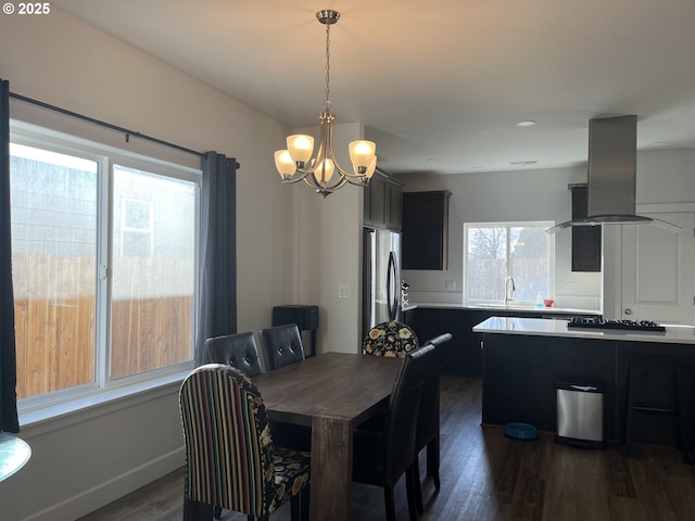 dining area featuring baseboards, dark wood finished floors, and a chandelier