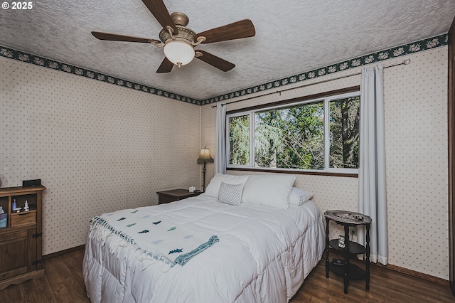 bedroom featuring wallpapered walls, dark wood finished floors, and a textured ceiling