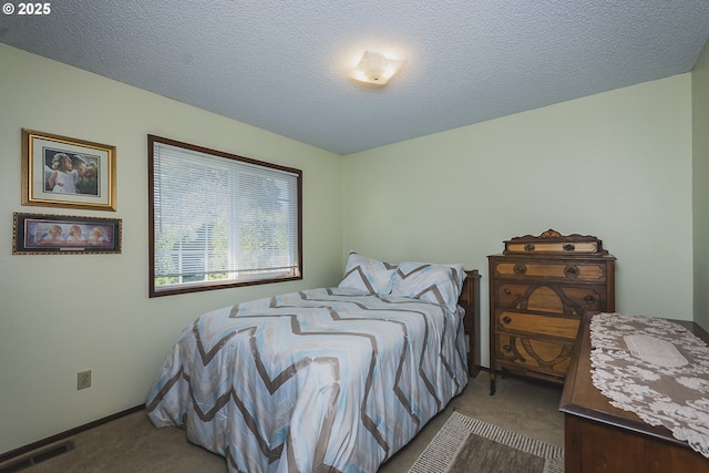 carpeted bedroom featuring a textured ceiling, visible vents, and baseboards