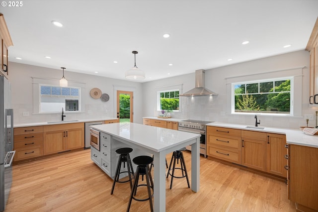 4072 NE 24th Ave, Portland, OR 97212 - kitchen featuring wall chimney range hood, high end stove, a sink, decorative backsplash, and recessed lighting