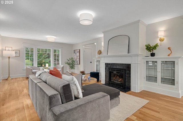 4072 NE 24th Ave, Portland, OR 97212 - living room with a tile fireplace, light wood-type flooring, and baseboards