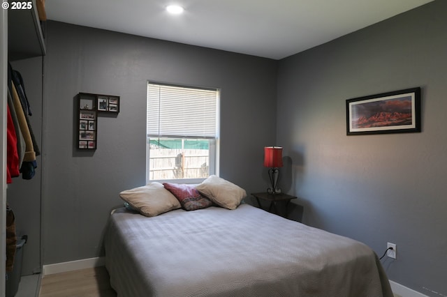 bedroom with baseboards and wood finished floors