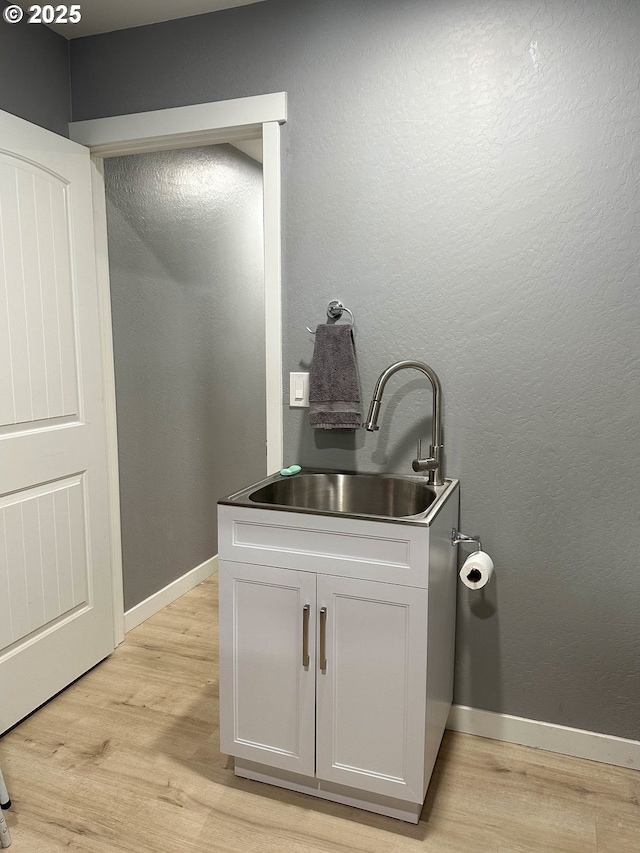 interior space featuring vanity, baseboards, and wood finished floors