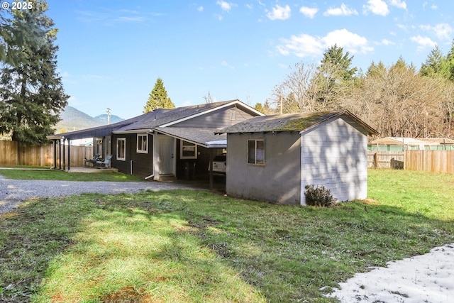 rear view of house featuring a yard, a mountain view, and a fenced backyard