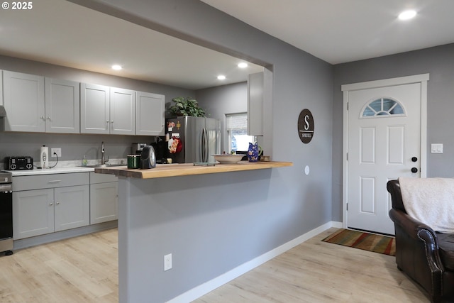 foyer entrance featuring light wood-type flooring, recessed lighting, and baseboards