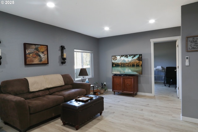 living room featuring recessed lighting, baseboards, and light wood finished floors