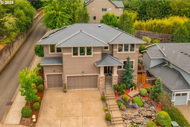 12483 SW Autumn View St, Tigard, OR 97224 - view of front of house with stone siding, concrete driveway, an attached garage, and roof with shingles