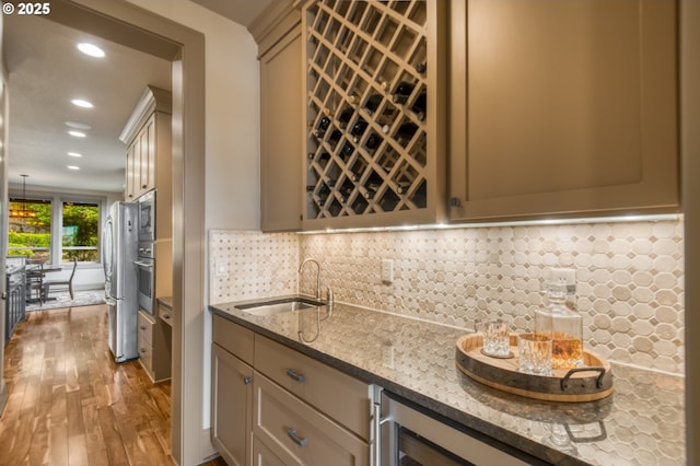 12483 SW Autumn View St, Tigard, OR 97224 - kitchen featuring light stone countertops, wood finished floors, recessed lighting, stainless steel appliances, and decorative backsplash