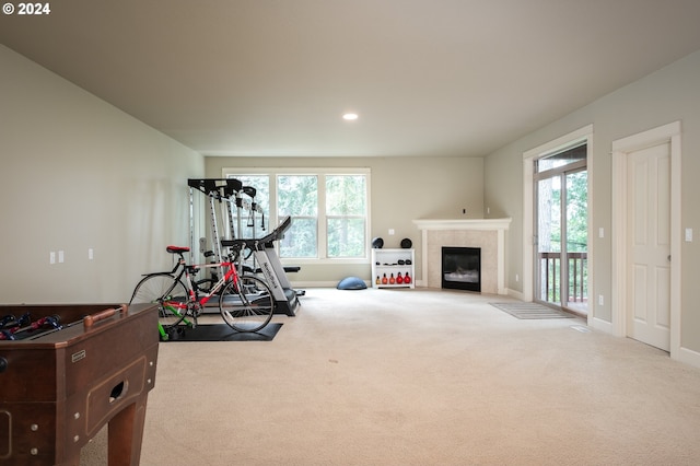 workout room featuring carpet and a tile fireplace