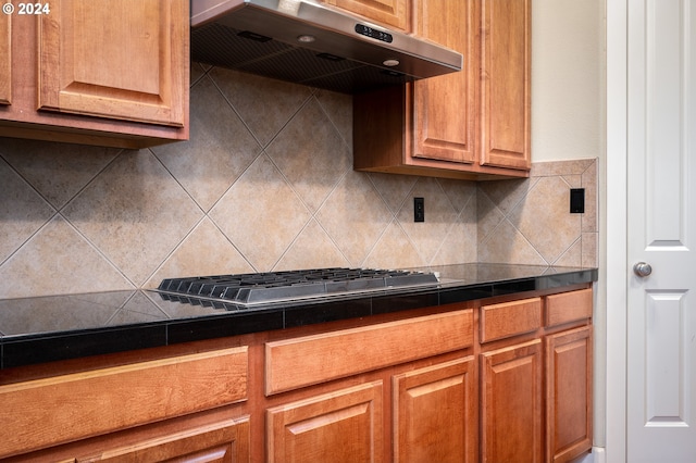 kitchen featuring backsplash, stainless steel gas stovetop, and ventilation hood