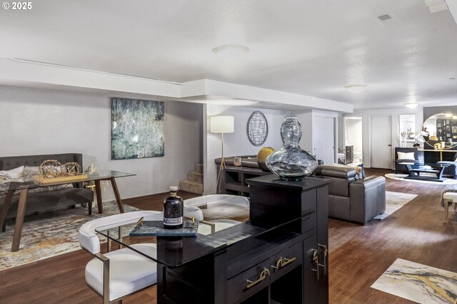 living room with a textured ceiling, a fireplace, and wood-type flooring