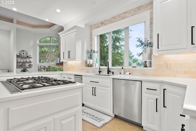 kitchen with sink, white cabinetry, crown molding, and appliances with stainless steel finishes