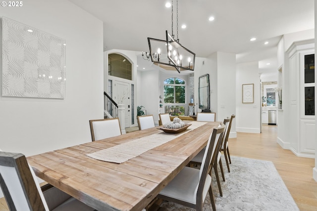 dining room with light hardwood / wood-style floors and an inviting chandelier