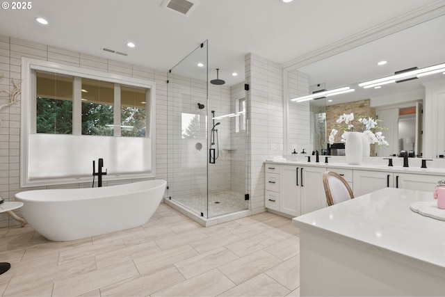 bathroom with tile walls, separate shower and tub, and vanity