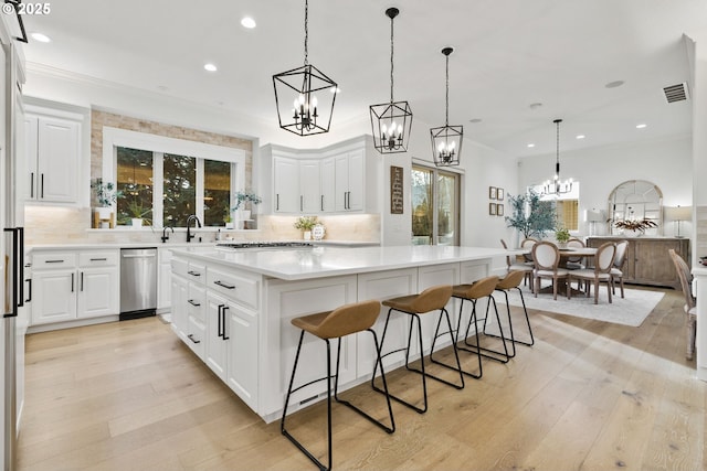 kitchen with stainless steel appliances, white cabinets, a center island, and backsplash