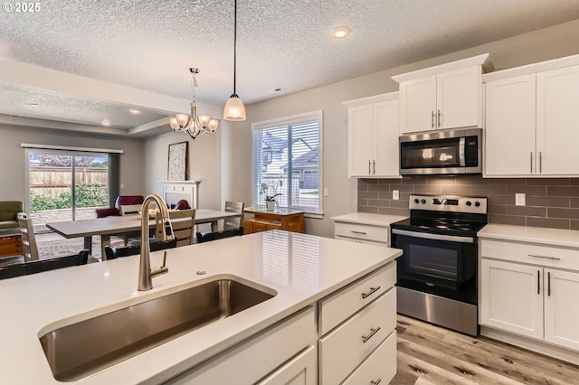 710 E Erica St, Yamhill, OR 97148 - kitchen featuring appliances with stainless steel finishes, a textured ceiling, light wood-type flooring, white cabinets, and light countertops